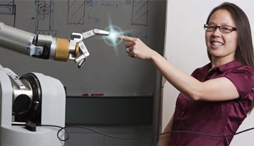 Veronica Santos, an assistant professor of mechanical engineering, demonstrates the capabilities of a robotic hand being developed in her Biomechatronics Lab.