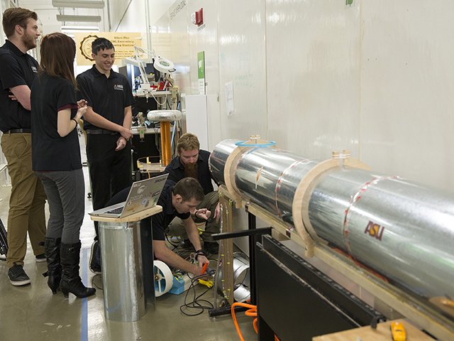 Members of the ASU Polytechnic Hyperloop Team prepare for a test run of their Hyperloop Pod prototype. Their design uses a fan and a compressor to create a cushion of air for levitation and linear electric motors to propel the pod forward. Photo by Nick Narducci/ASU