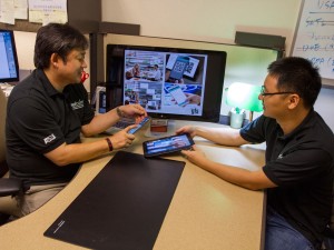 Gail-Joon Ahn (left) demonstrates some of the SEFCOM lab research with a student.