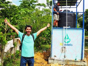 Mark Huerta celebrates in front of the finished water filtration system in the Dominican Republic.