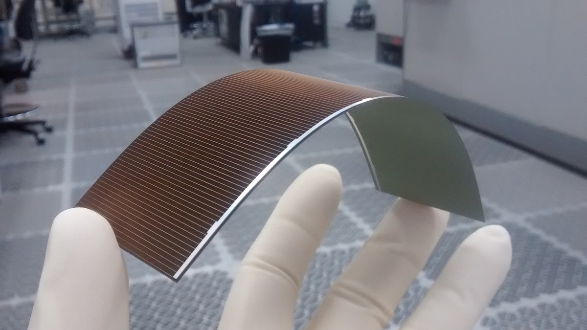 A thin solar cell being flexed in a hand
