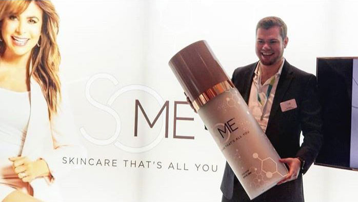 man holding an oversized skincare product